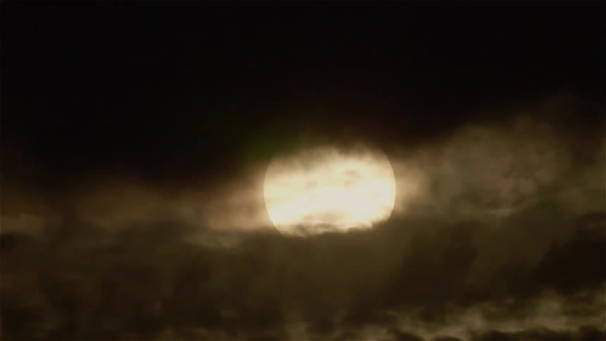 Clouds float in front of the moon
