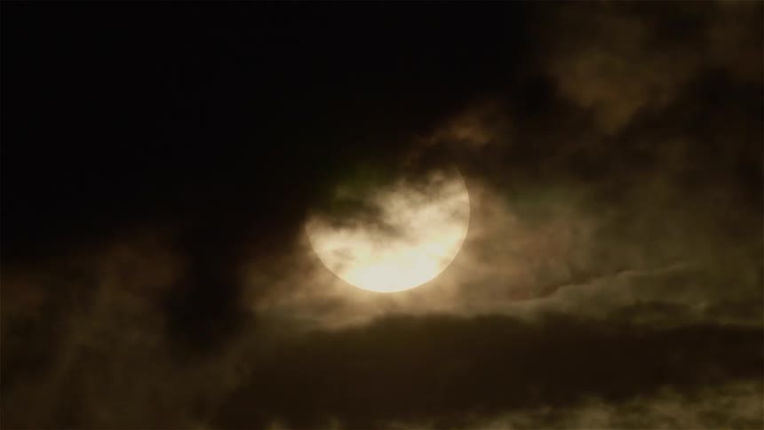 Clouds float in front of the moon