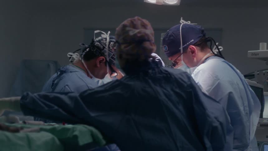 A team of doctors and nurses perform surgery on a patient