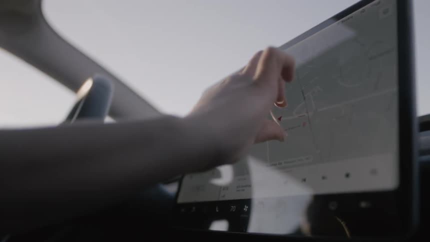 A person moves a map on his device as they drive