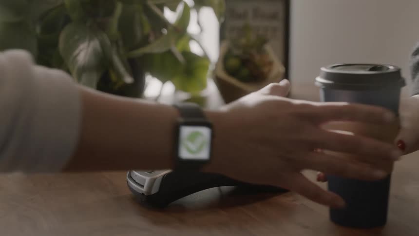 Woman uses smartwatch to pay for her coffee