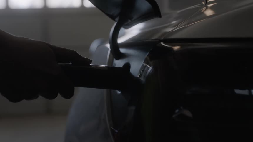A person plugs in an electric car to charge