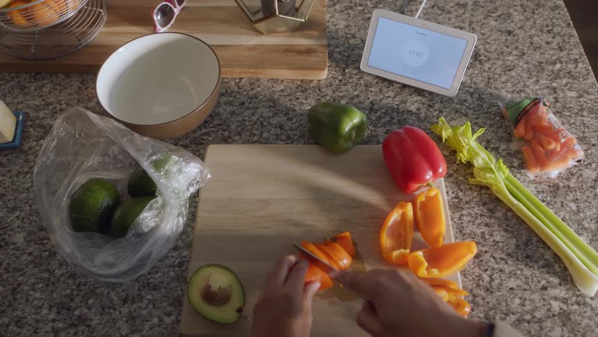 A person cops peppers on a cutting board