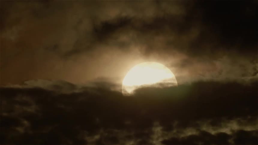 The clouds move over the setting sun
