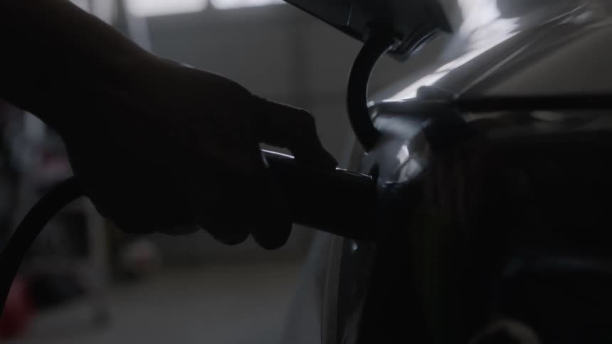 A person removes the charger from the car