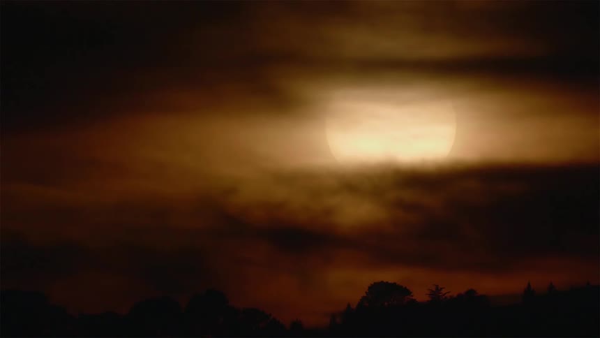 Sun shines brightly behind the clouds