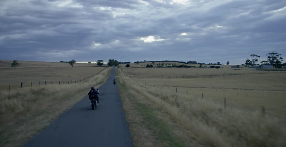 Motorcyclists ride on a rural road