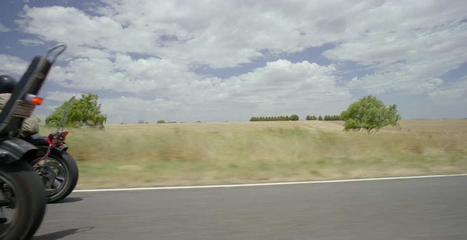 Motorcyclists ride on a rural road