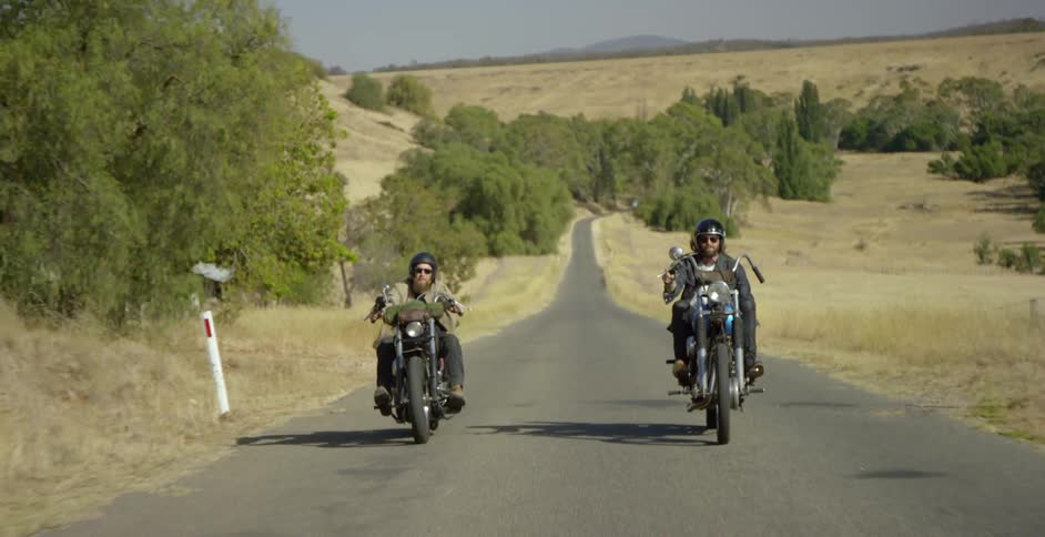 Two people ride their motorcycles uphill