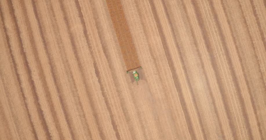 A tractor drives across a dirt field