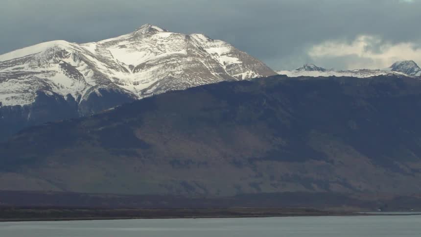 Clouds float above snowy mountains