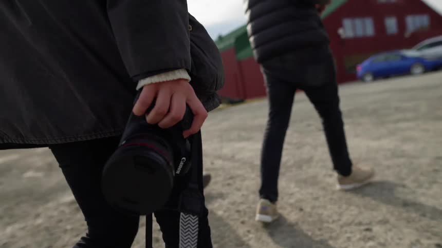 A photographer carries a camera outside