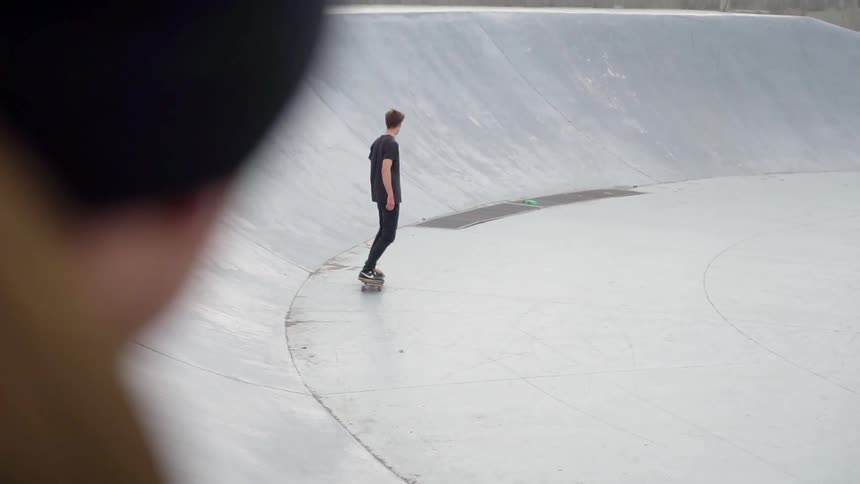Man rides on a skateboard in a skatepark