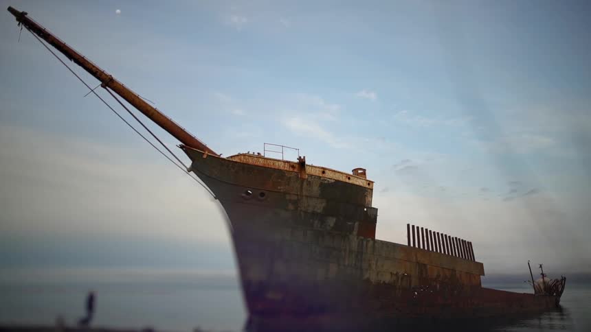 A rusty ship floats on a lake