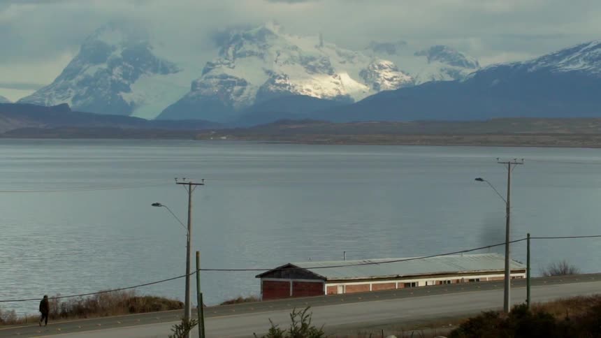 A building sits next to a mountain lake