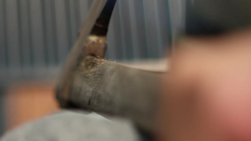 Person's hands grip onto a sharp ax