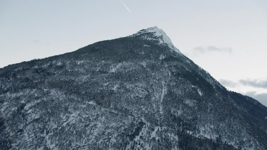 Snow covers a mountain peak at sunrise