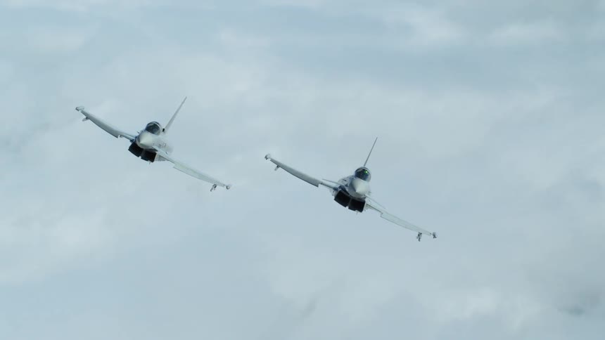 Two planes fly side by side above the clouds