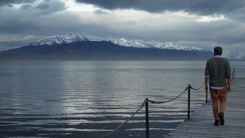 Rippling lake surrounded by snowy mountains