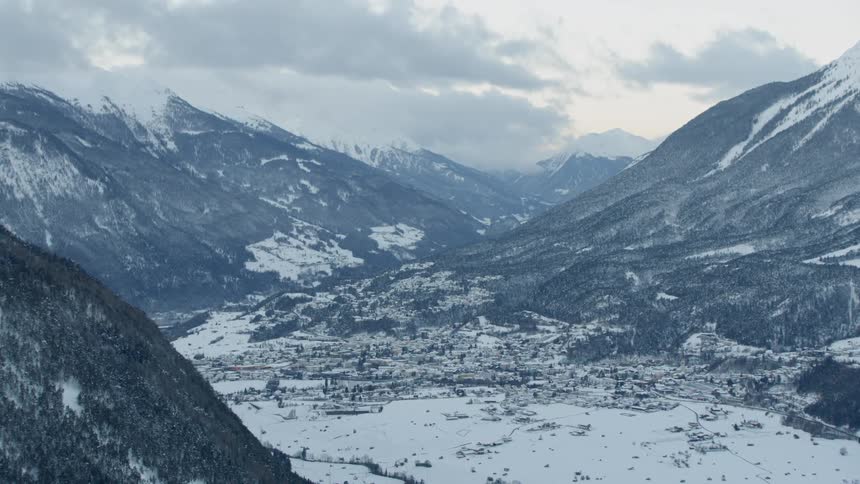 Clouds float above snowy mountains