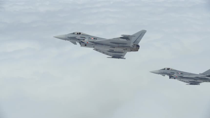 Fighter jets fly above clouds
