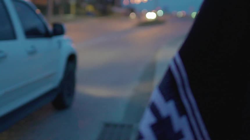 A pickup truck passes a person walking on the sidewalk