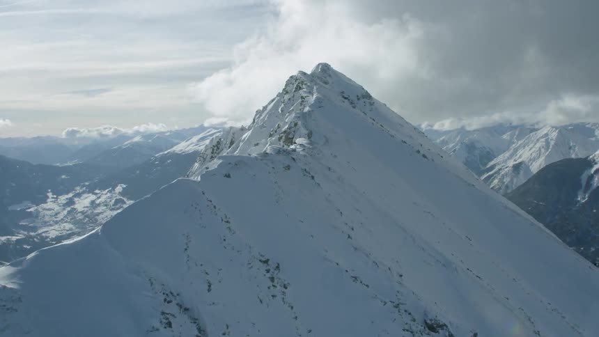 Helicopter timelapse flying towards a cloudy mountain peak
