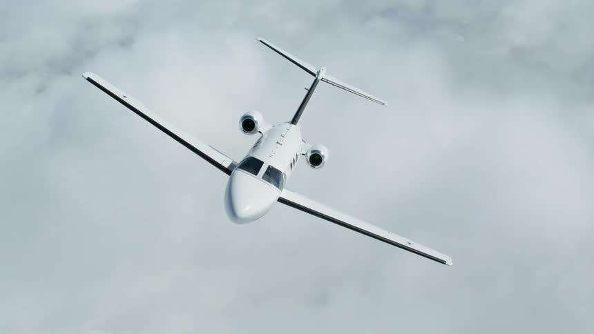 A luxury jet is flying above the clouds during the day