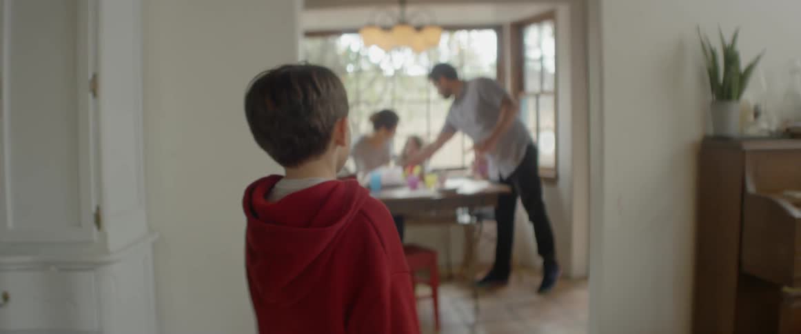A young boy walks into a dining room