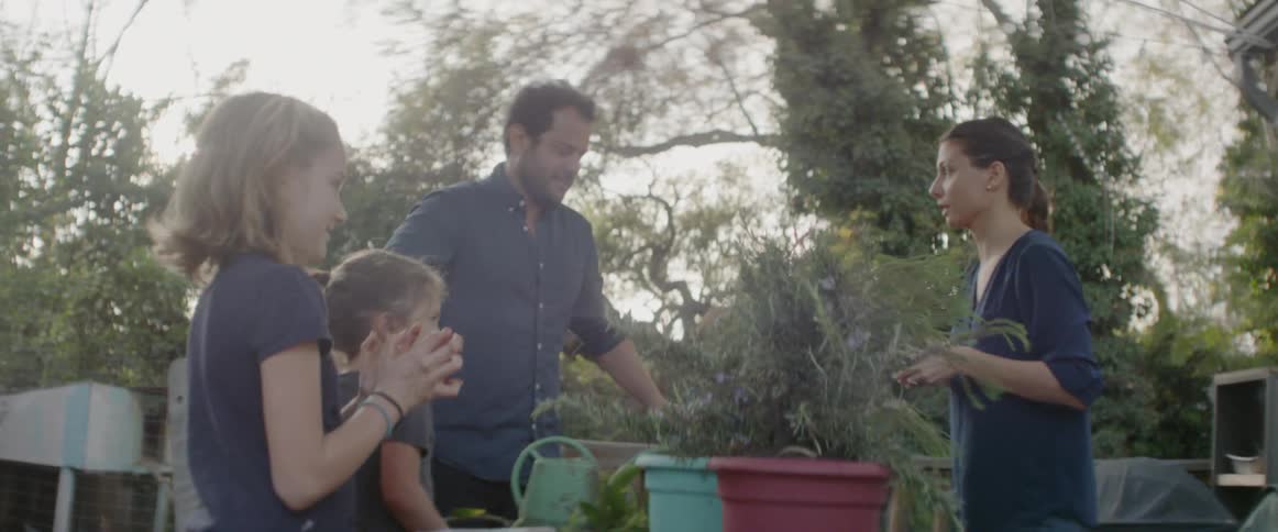 A family are planting items on a table