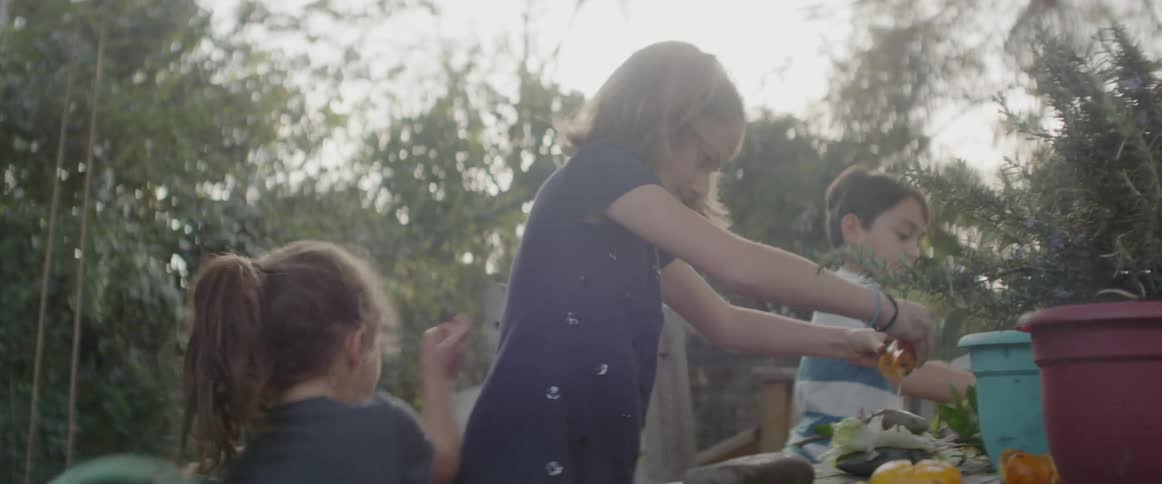 The children work on a project with plants in the yard
