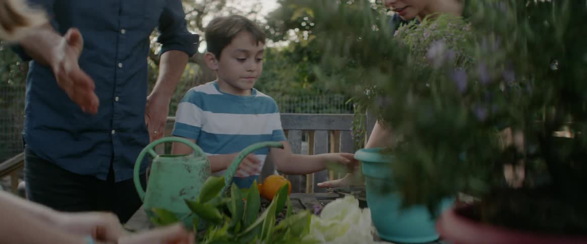 A family sits around a garden table