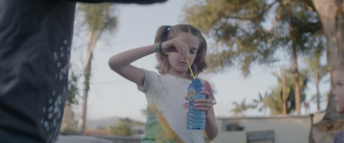 Child blows bubbles in a yard