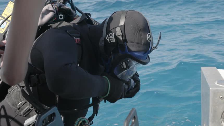 The diver is attaching his gear