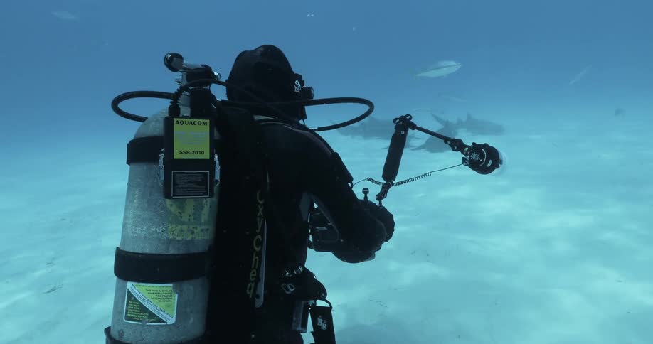 Deep sea diver uses equipment at the bottom of the ocean