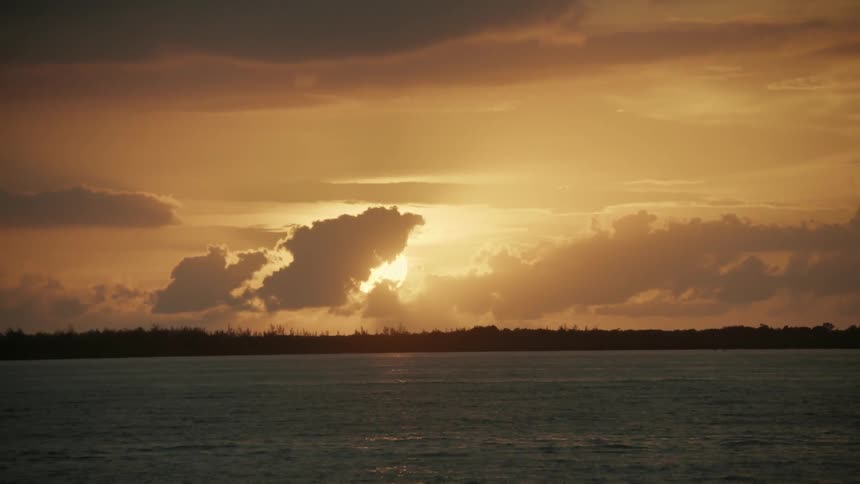The sun shines above a flowing water body
