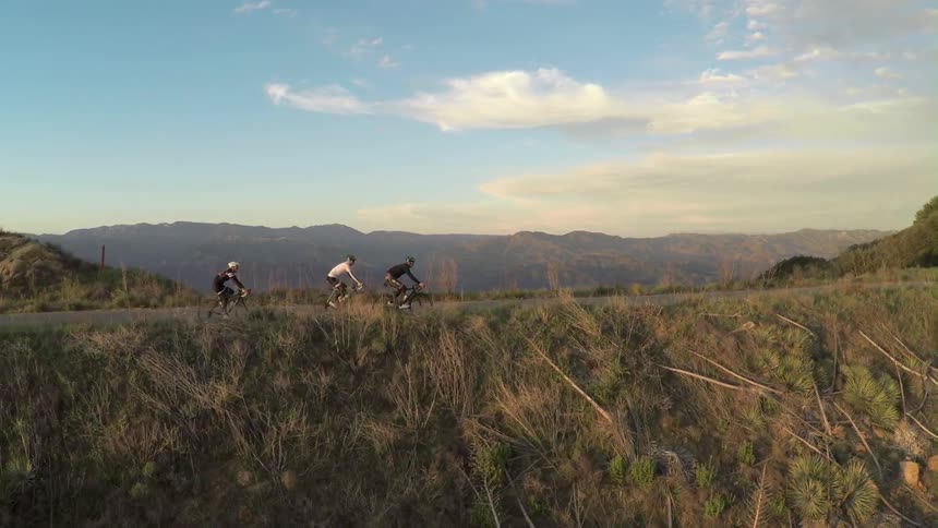 Three people riding their bikes on a path