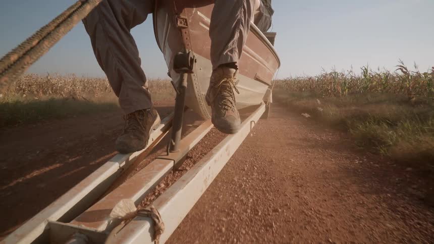Two people sit on the boat as it is being towed on the trail