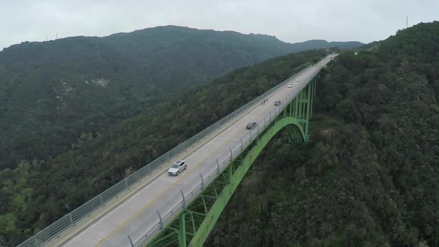 Large green bridge filling the gap between mountains