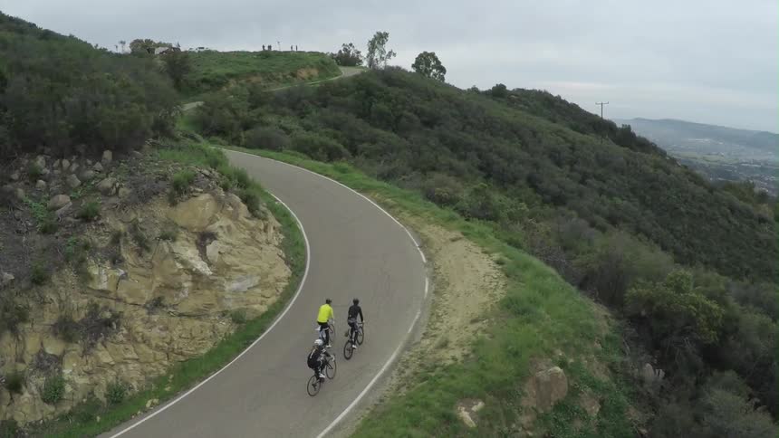 Bicyclists ride up a hill
