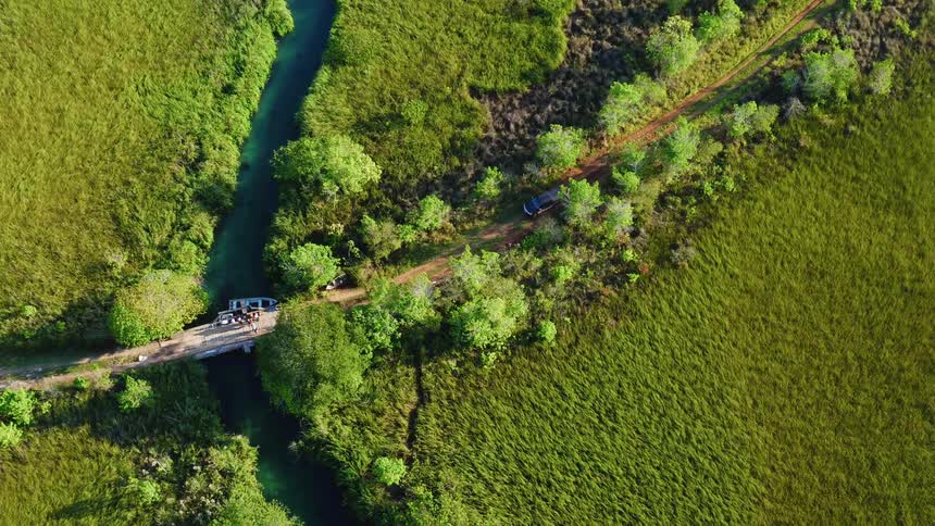 Activity on a bridge spanning a small river as seen from high above