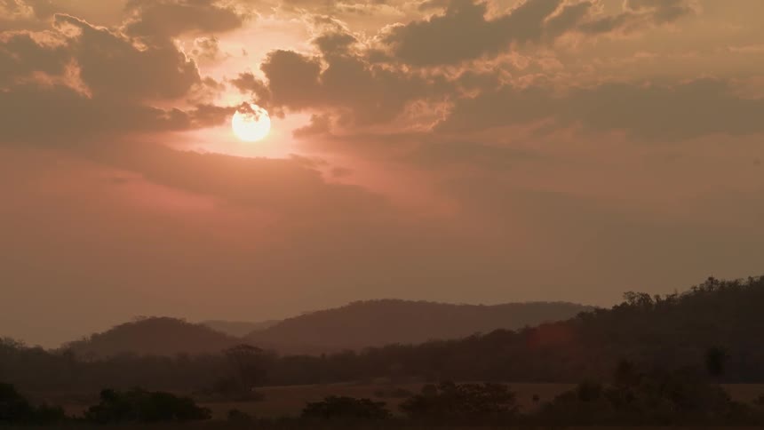 Clouds float in front of a setting sun