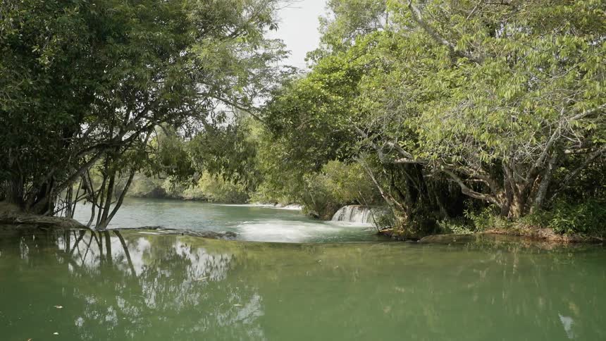 The stream is green and goes to a waterfall