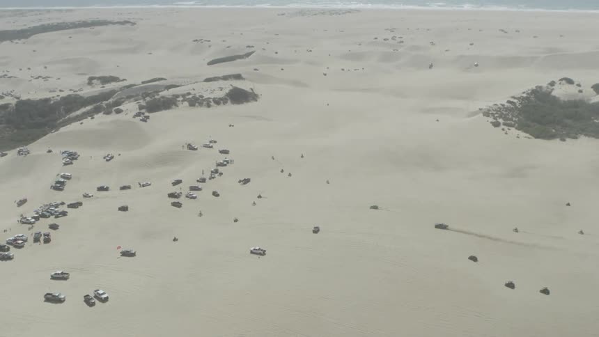Vehicles drive on sand in the desert
