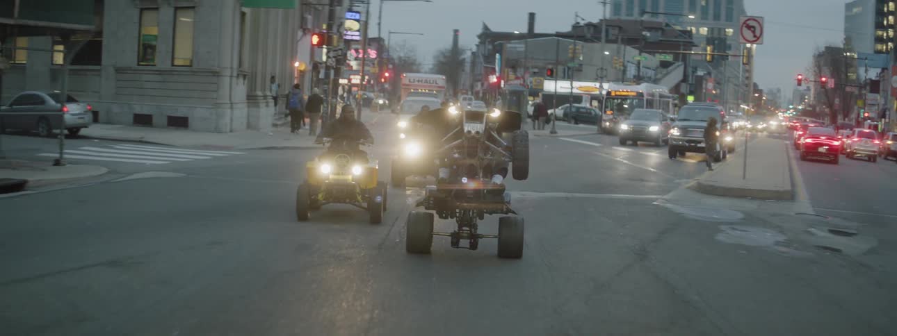 A group of men ride atvs on a city street