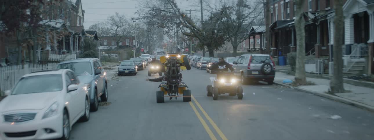 A group of men ride atvs on a city street