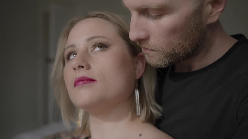 Man touches a woman's hair and puts his face on hers