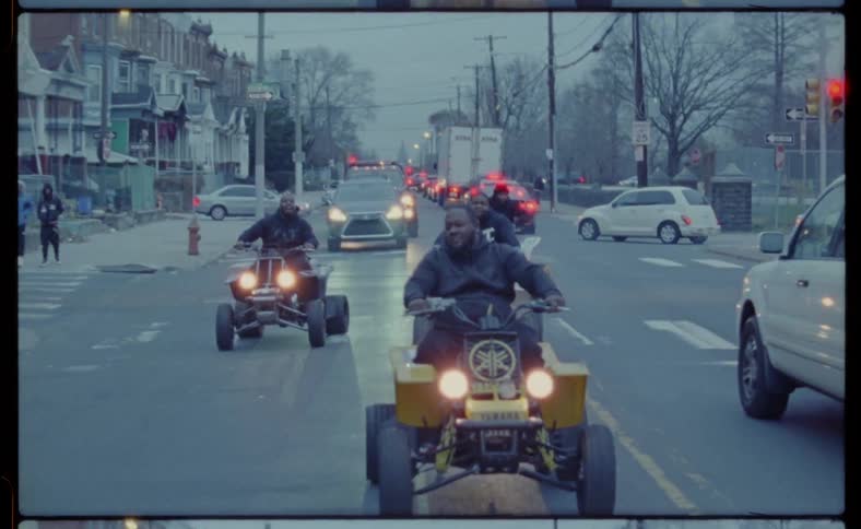 Four wheelers are drive on a city street