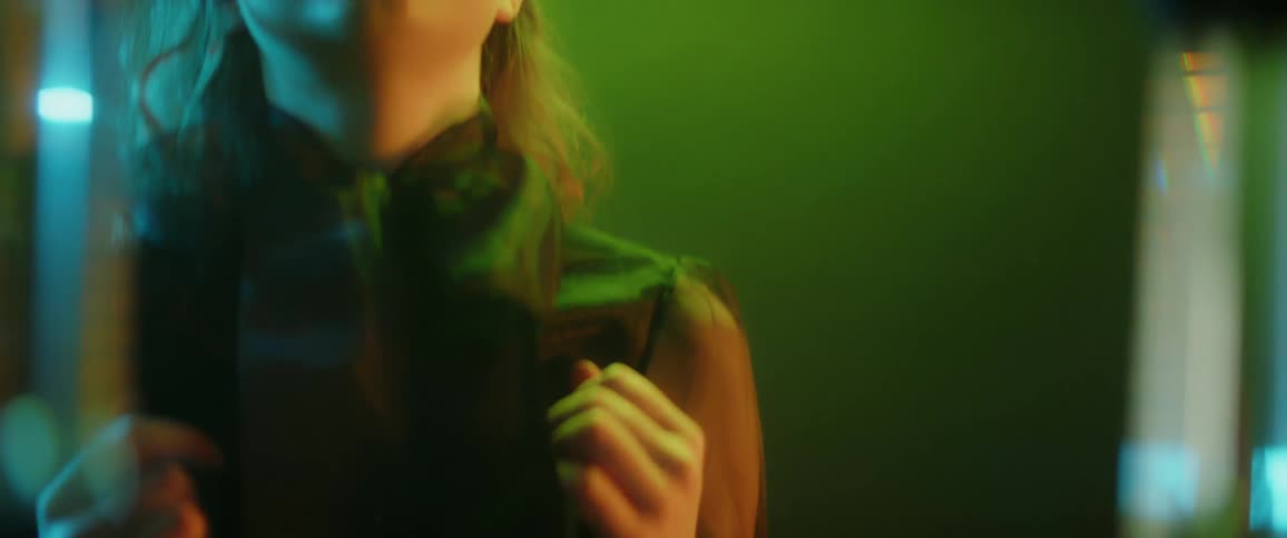 A woman reaches up and brushes her hair