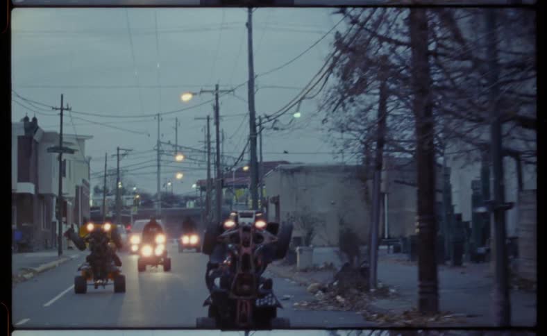 A group of men ride atvs on a city street